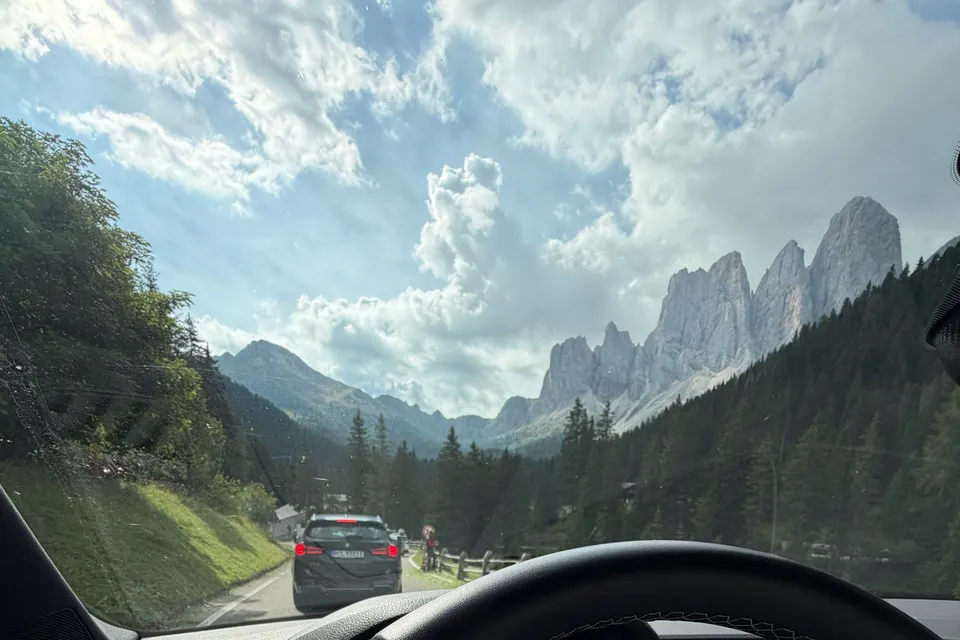 Mountain peaks seen through a car windshield on an alpine road